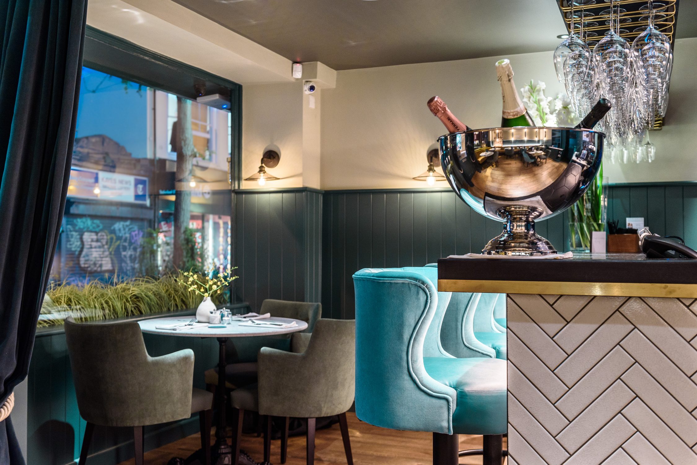 Interior view of a restaurant, tiled bar with herringbone pattern white tile seen in the fourground. Stickland Wright Architects and Interior Design, Brighton