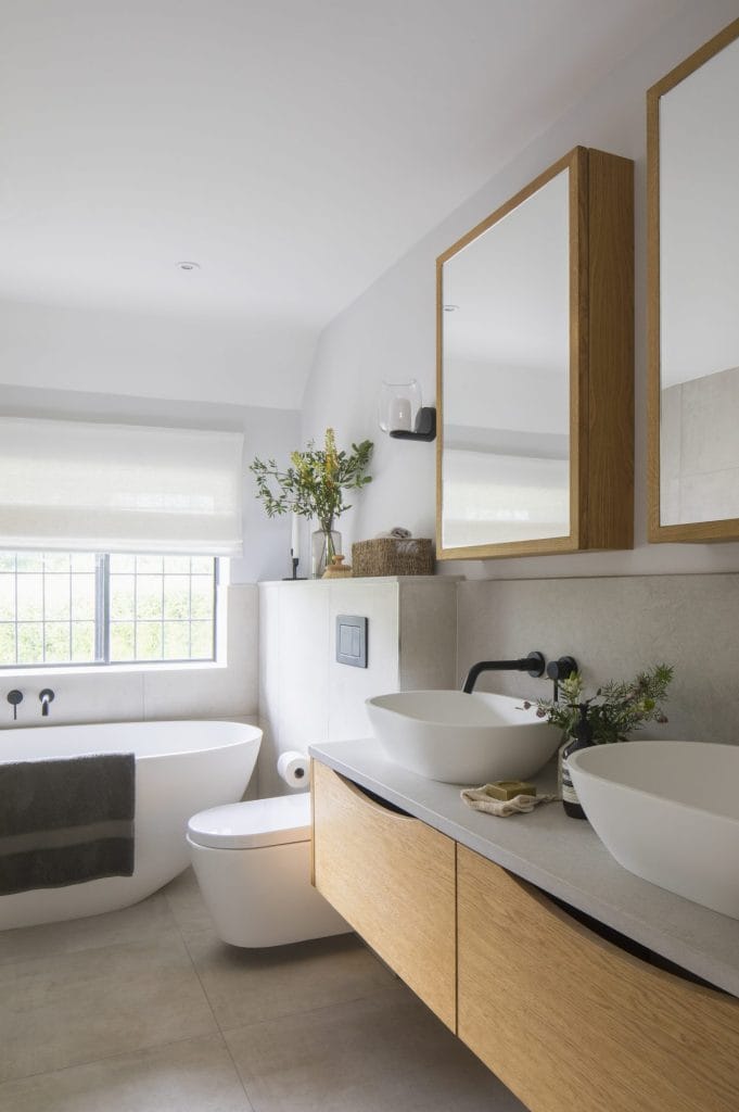Heritage bathroom with two sinks in a Sussex residential conversion, featuring architectural and interior design elements.