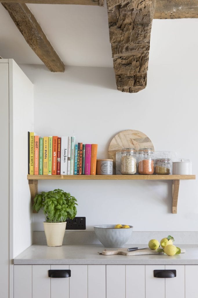 Kitchen with shelves and wooden beam in Heritage Residential Conversion, Sussex. Stickland Wright Architecture and Interior Design