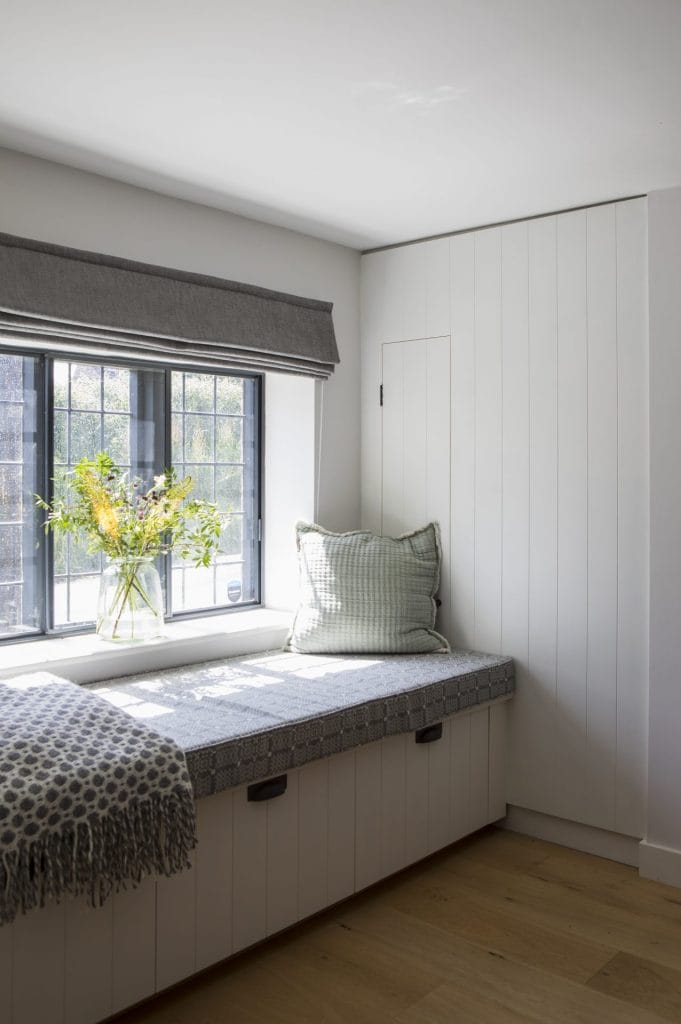 Interior of Sussex residential conversion featuring bespoke window seat with integrated storage. Stickland Wright Architecture and Interior Design